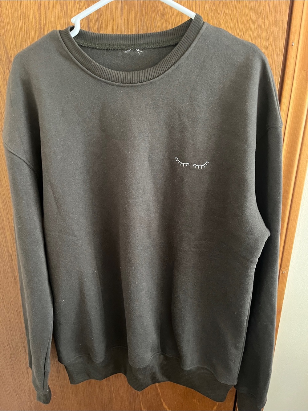 Black Crewneck Sweatshirt with Eyelash Graphic.